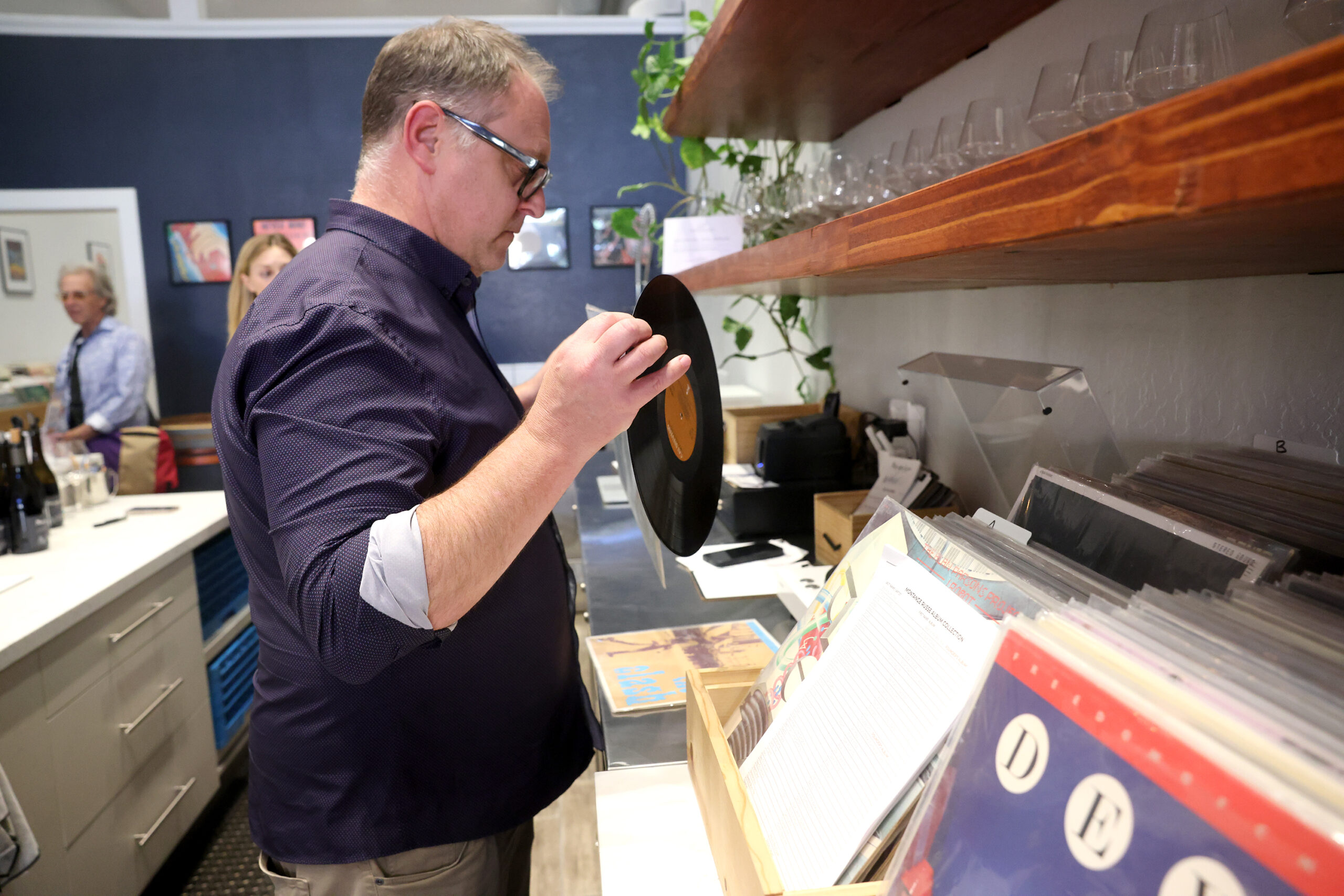 Owner and winemaker Kevin Bersofsky puts on a record during a Petaluma Chamber of Commerce mixer at the Montagne Russe Winery and Record Lounge in Petaluma Thursday, July 31, 2025. (Beth Schlanker / The Press Democrat)