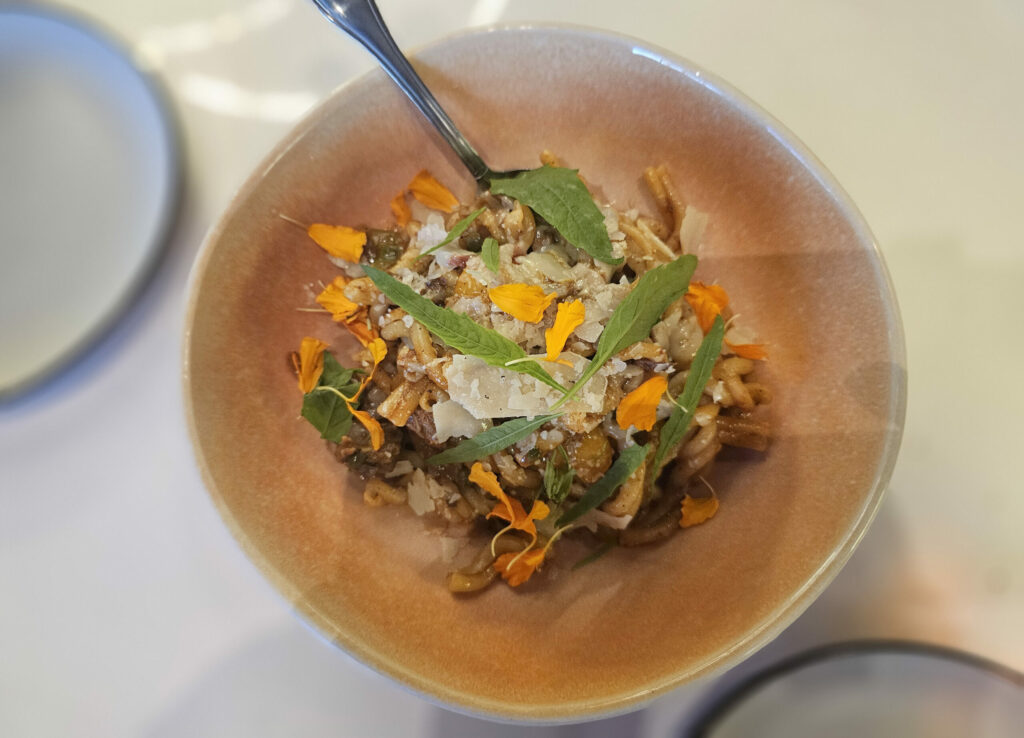 Braised beef birria and strozzapreti (a hand-twisted pasta) with Parmesan, capers and tart cherry tomatoes at chef Carlos Mojica's dinner pop-up at Aroma de Cafe in Santa Rosa. (Heather Irwin/The Press Democrat)