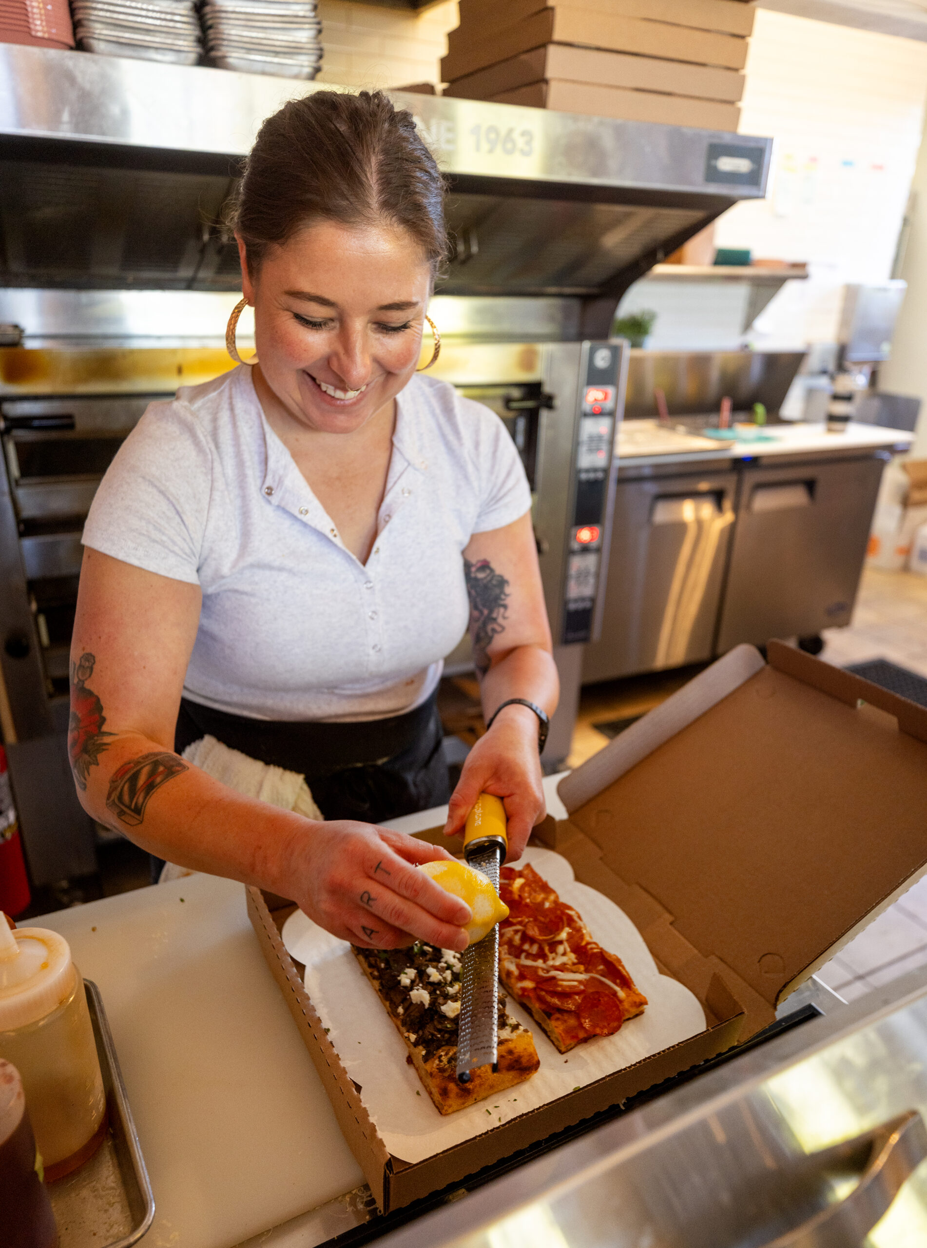 Co-owner Leith Leiser Miller adds lemon zest to Roman-style sourdough pizzas