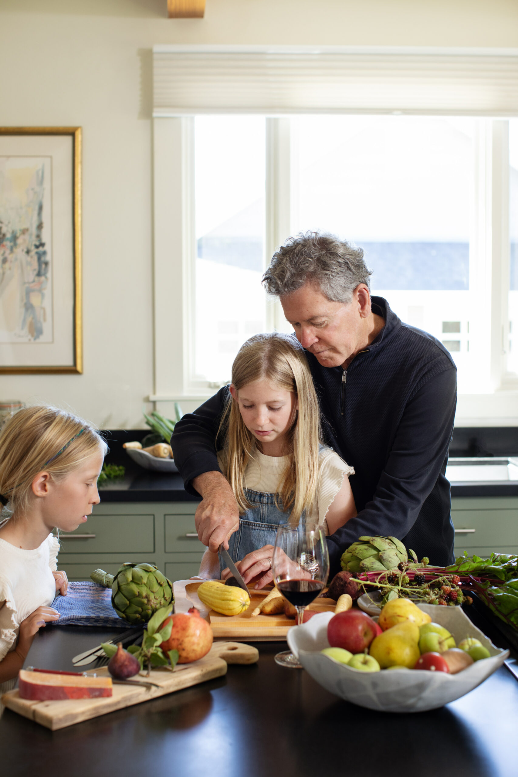Winemaker Paul Hobbs prepares vegetables for dinner with the help of daughters Sophia and Louisa. (Eileen Roche / for Sonoma Magazine)