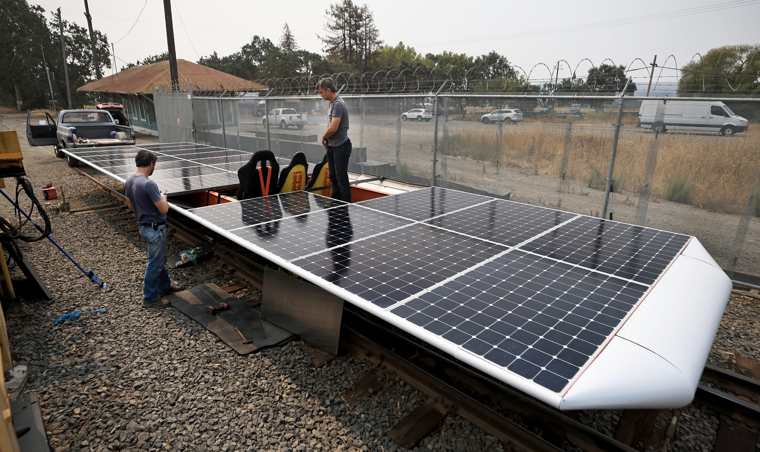 Eric Houston and Marco Fucci di Napoli prepare to place the final panel on Solar Train in Schellville, Friday, Aug. 20, 2021. (Kent Porter / The Press Democrat) 