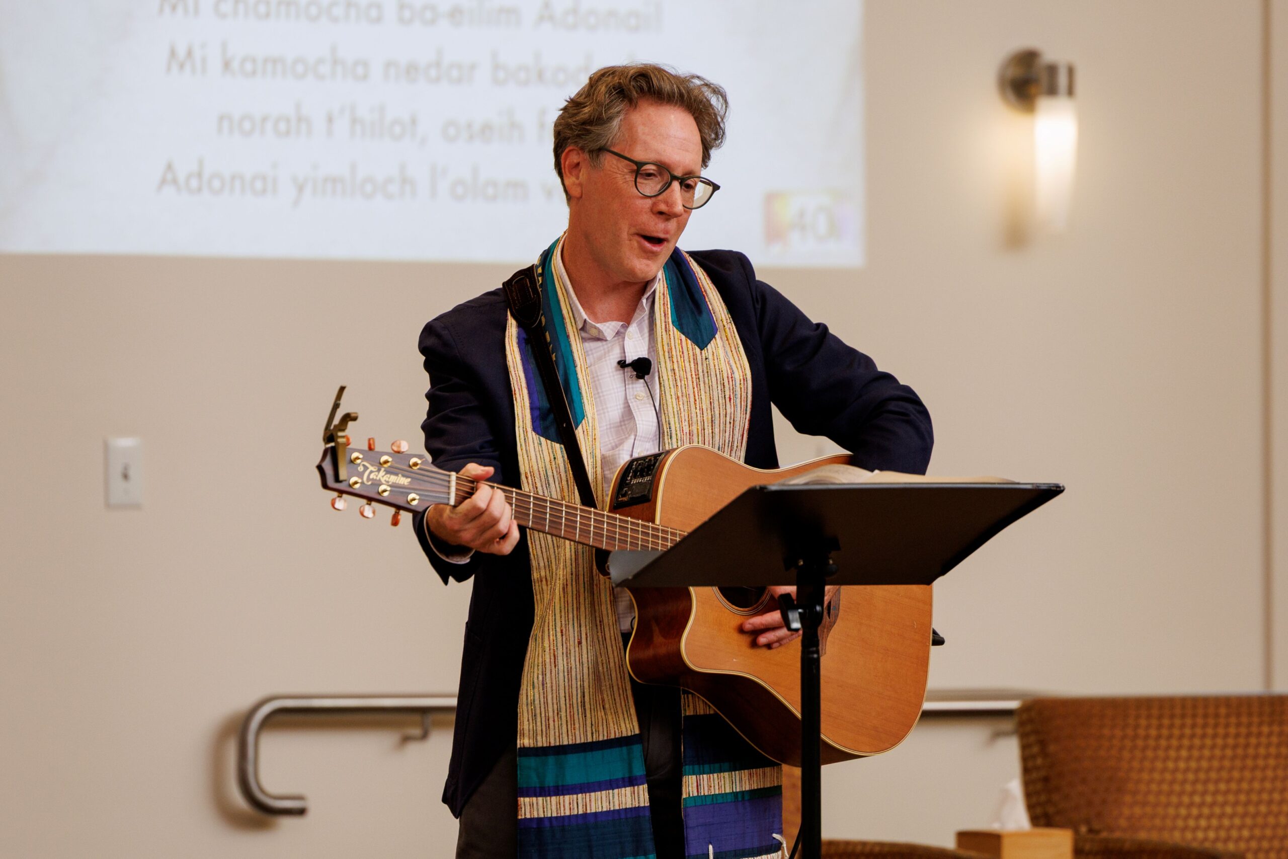 Rabbi Jeremy Morrison plays his guitar in front of his congregation during Shabbat at Congregation Shomrei Torah on August 15, 2025. (Abraham Fuentes/For The Press Democrat)