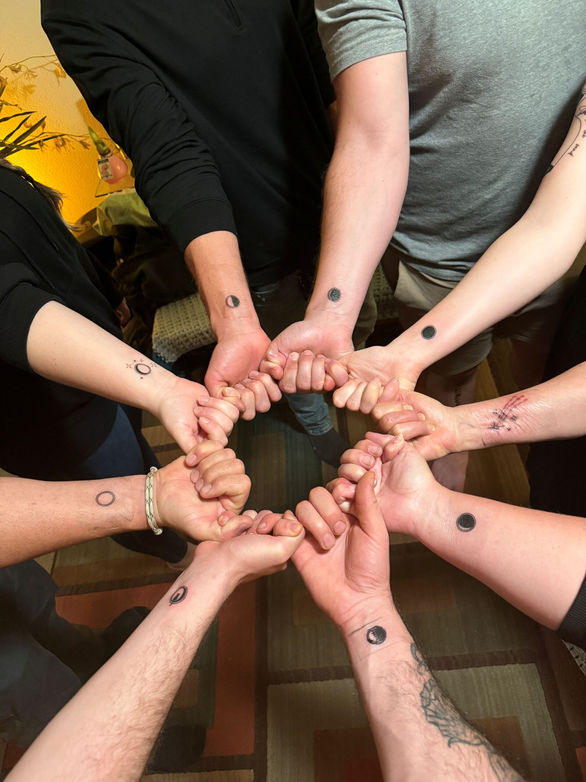Kat Pringle's family pose with tattoos drawn using ink infused with her ashes. The tattoos depict different phases of the moon, inspired by Kat's love for the night sky and one of her own detailed tattoos that incorporated the moon. (Courtesy of Vera Tabib)