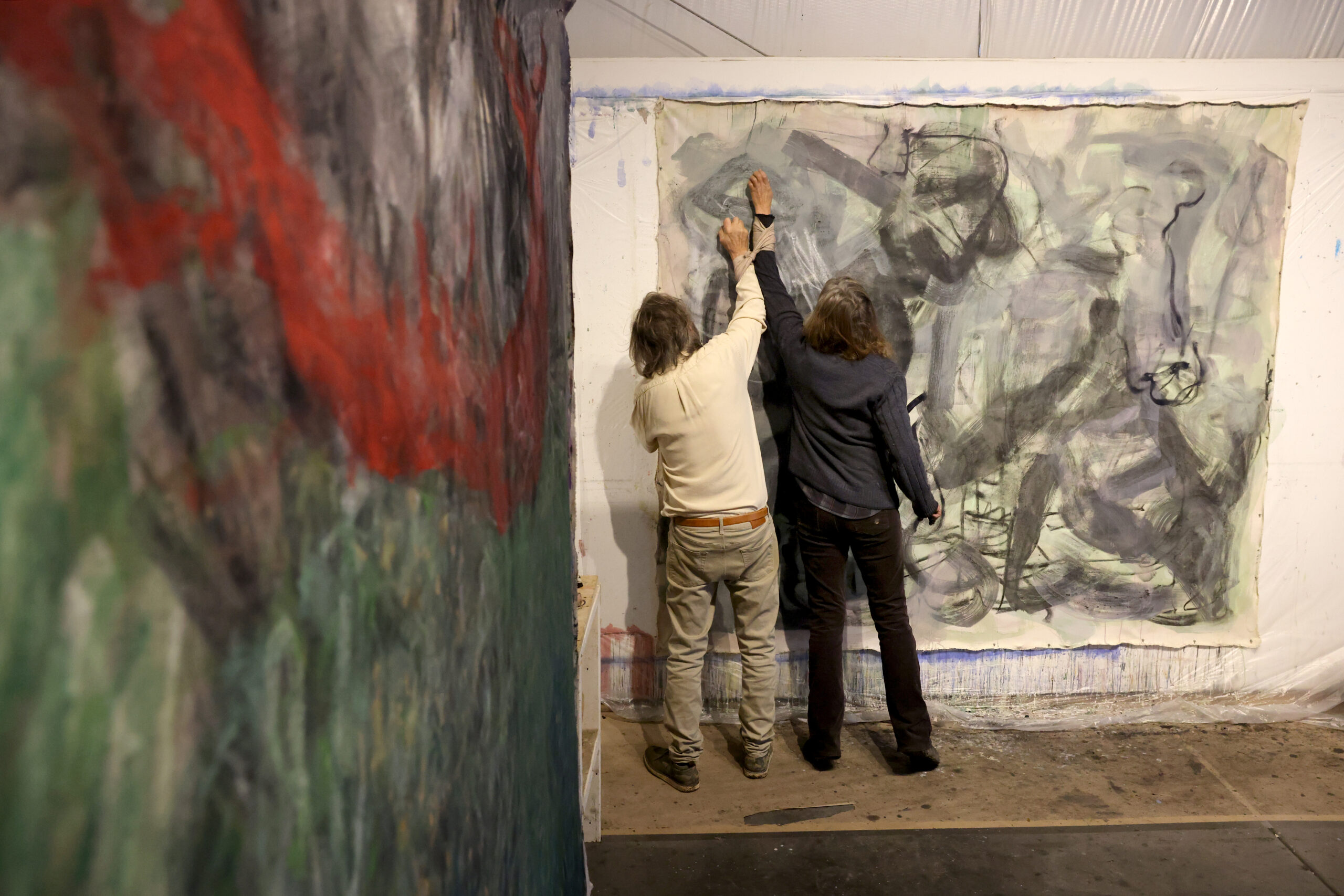 Artists Pamela Holmes and Winston Gourley draw on a canvas at their Stranger Worth art studio