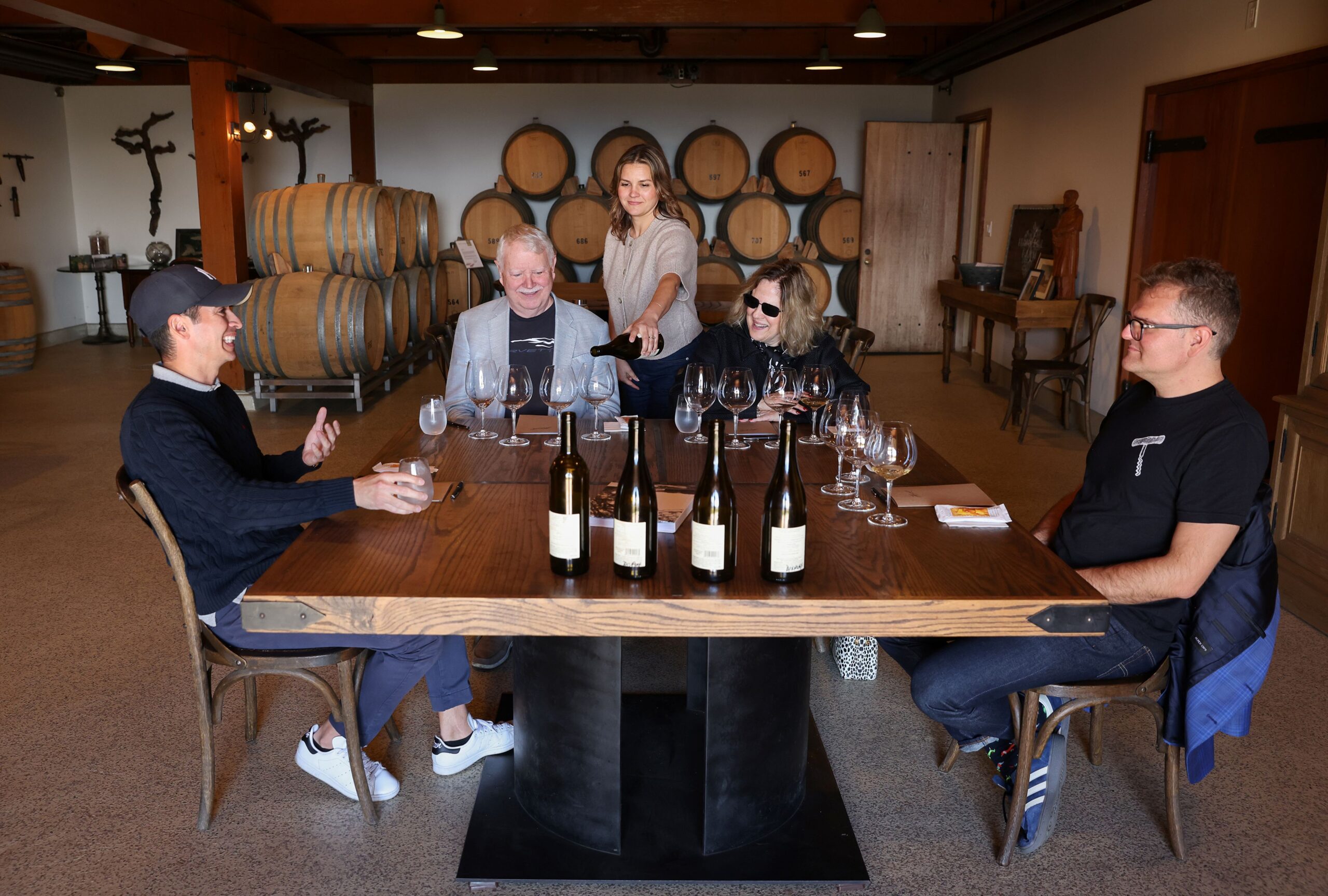 Hanzell Vineyards estate educator Ursula Ayala, center, pours wine for visitors Gustav Gustavsson, left, and Ralph, Nancy and Nicholas Schroeder in Sonoma on Friday, November 7, 2025. (Christopher Chung/The Press Democrat)