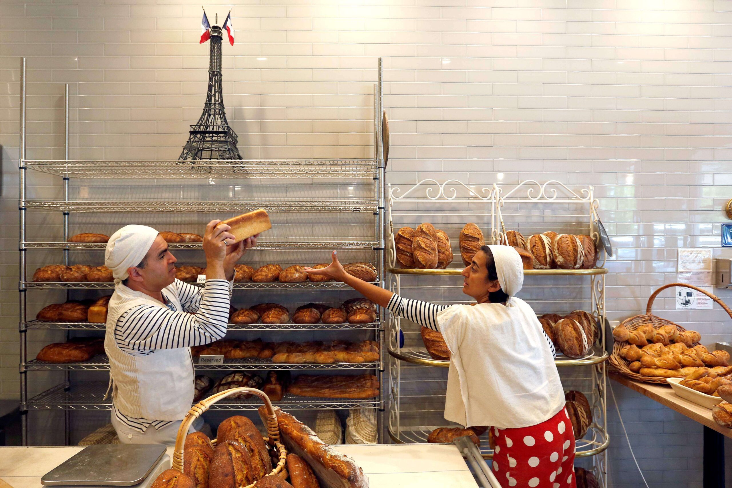 Nas Salamati, left, and his wife Najine Shariat restock the rows of bread at their bakery, Goguette Bread, in Santa Rosa on Wednesday, July 18, 2018. (Alvin Jornada / The Press Democrat)