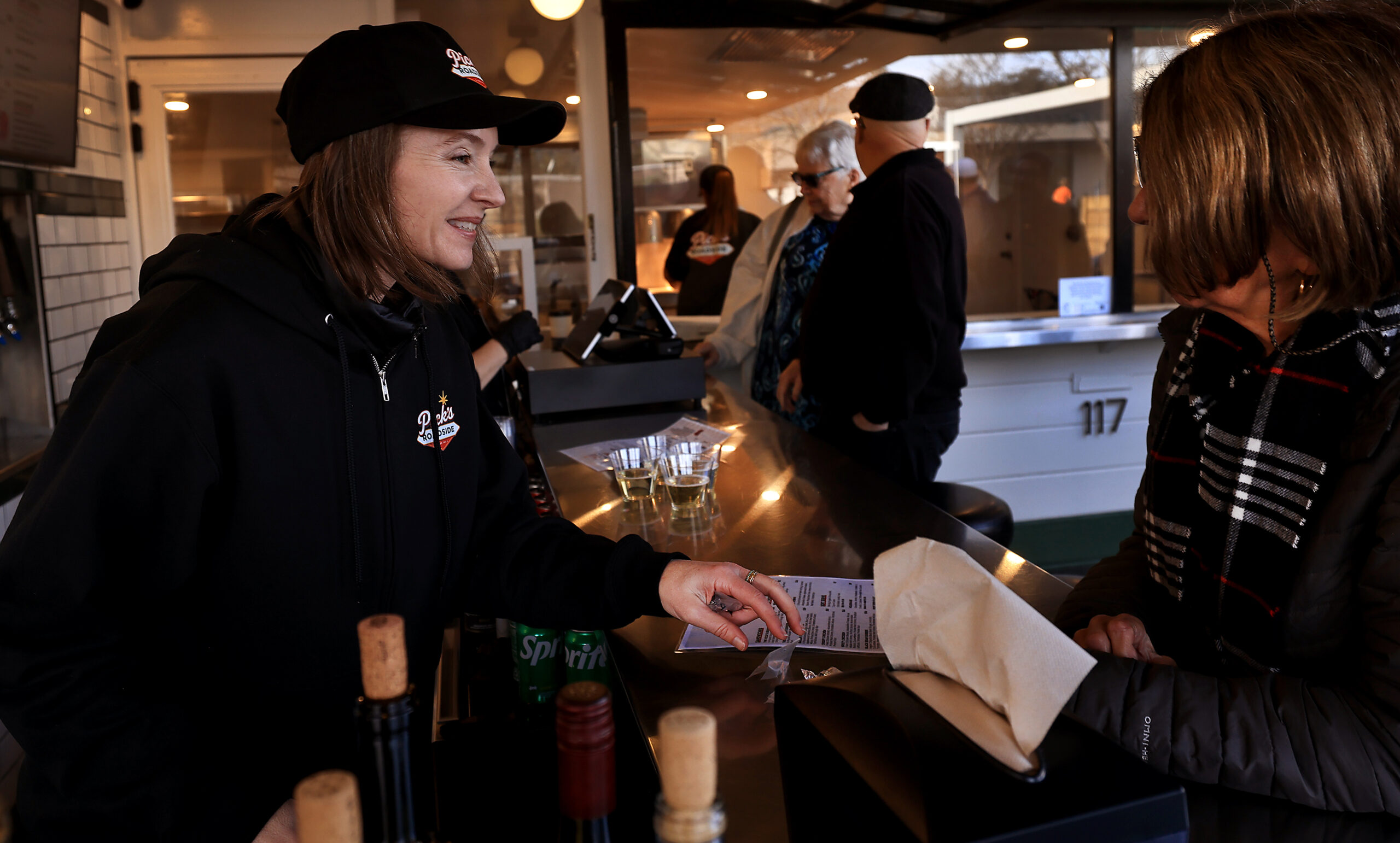 Amber Lanier, a fifth-generation Cloverdale resident and general manager of Pick’s Roadside, left, suggests a menu item as Pick’s opens, Saturday, Jan. 10, 2026. (Kent Porter / The Press Democrat)