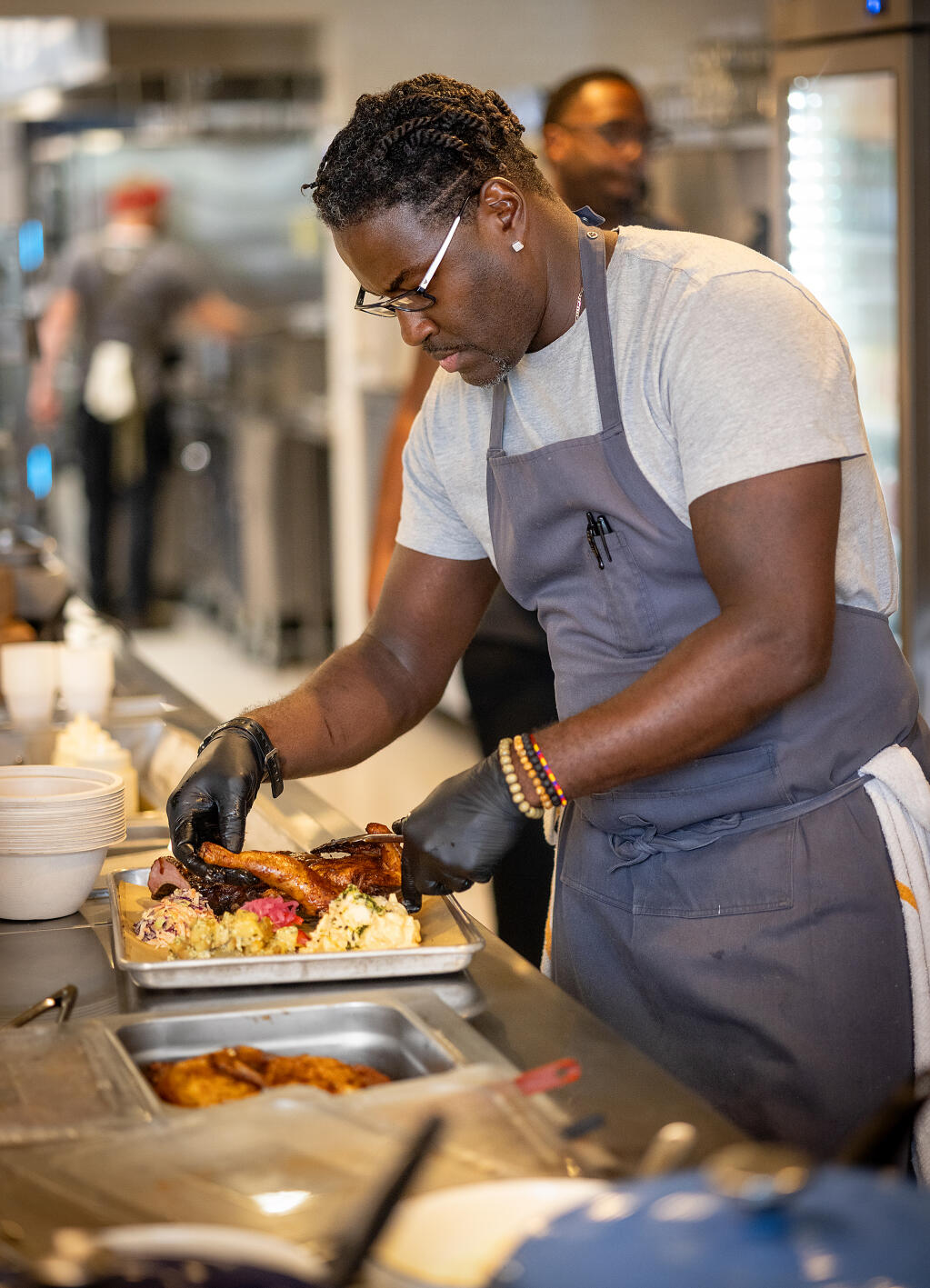 Chef Darryl Bell prepares a tray with all the meats at Stateline Road Smokehouse Friday, August 23, 2024 in Napa. (John Burgess / The Press Democrat)