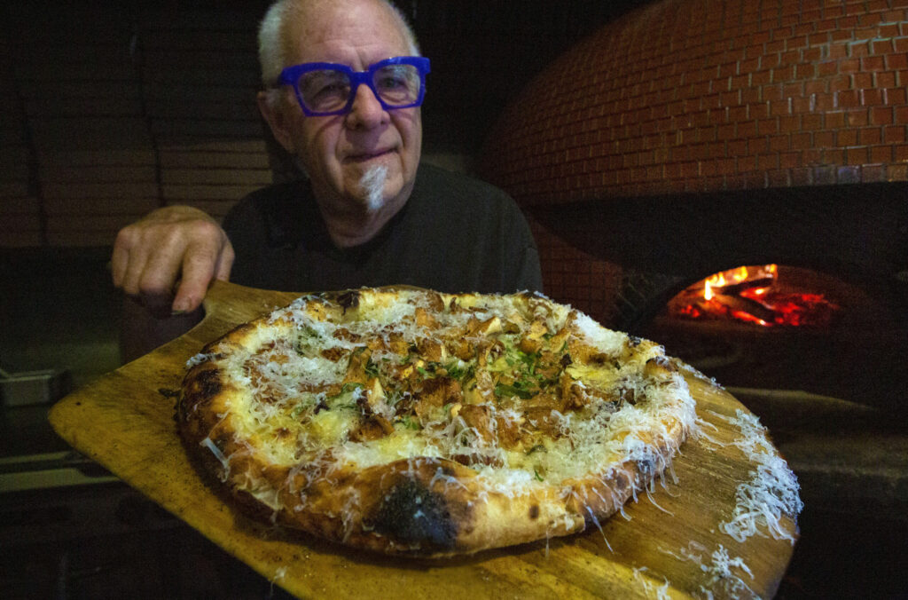 Rob Larman with a chanterelle mushroom pizza fresh from the wood-fired oven, topped with a dusting of Parmesan cheese, at his Il Fuoco restaurant on Highway 12 in Boyes Hot Springs. Photo taken on Monday, Nov. 6, 2023. (Robbi Pengelly/Index-Tribune)