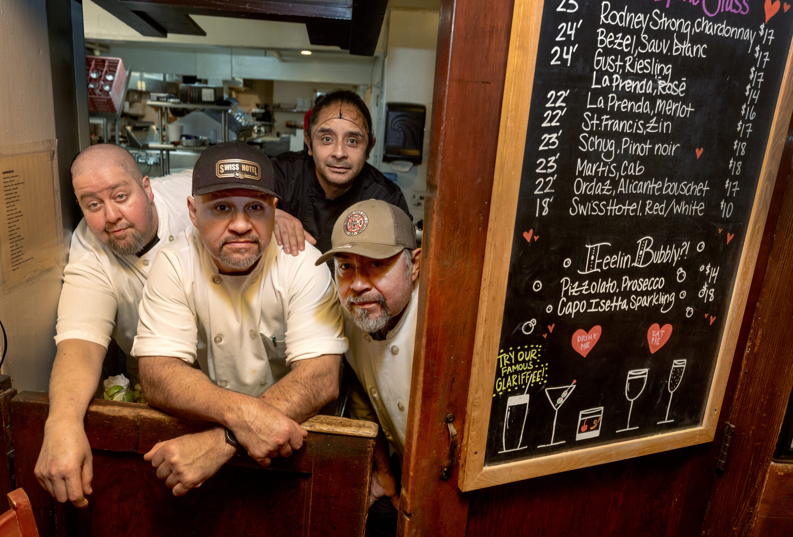 The kitchen staff behind the swinging door into the bar at the historic Swiss Hotel Thursday, Feb. 19, 2026 on the square in Sonoma. (John Burgess/The Press Democrat)