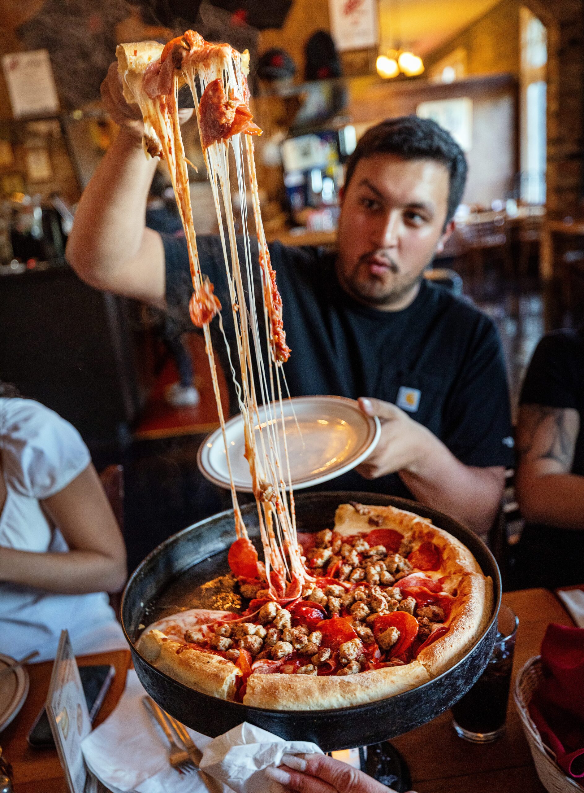 A customer pulls a slice from a deep-dish pizza pie at Old Chicago Pizza