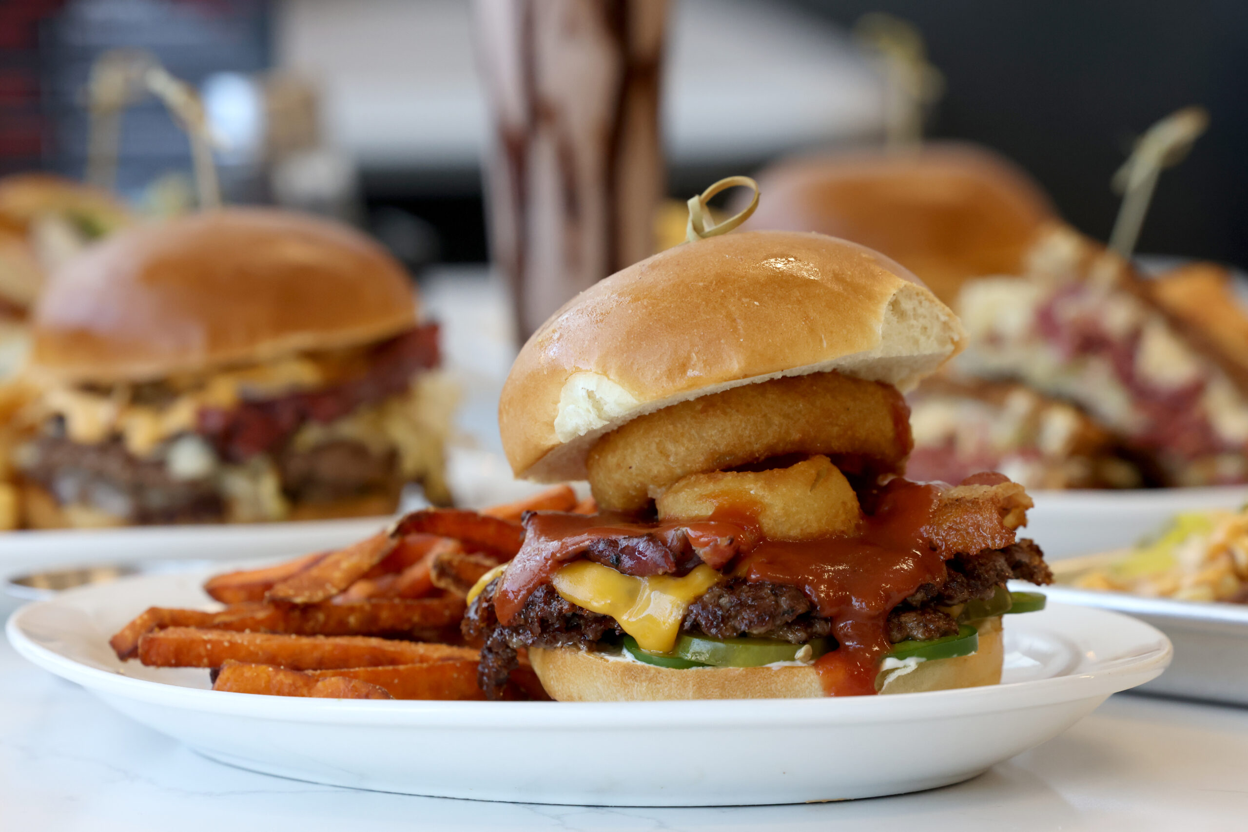 The BBQ Burger, made with two beef patties, onion rings, bacon, jalapeno, pickles, cheddar cheese, barbecue sauce and mayo, with a side of sweet potato fries at Pressed in Rohnert Park Friday, April 17, 2026. (Beth Schlanker / The Press Democrat)