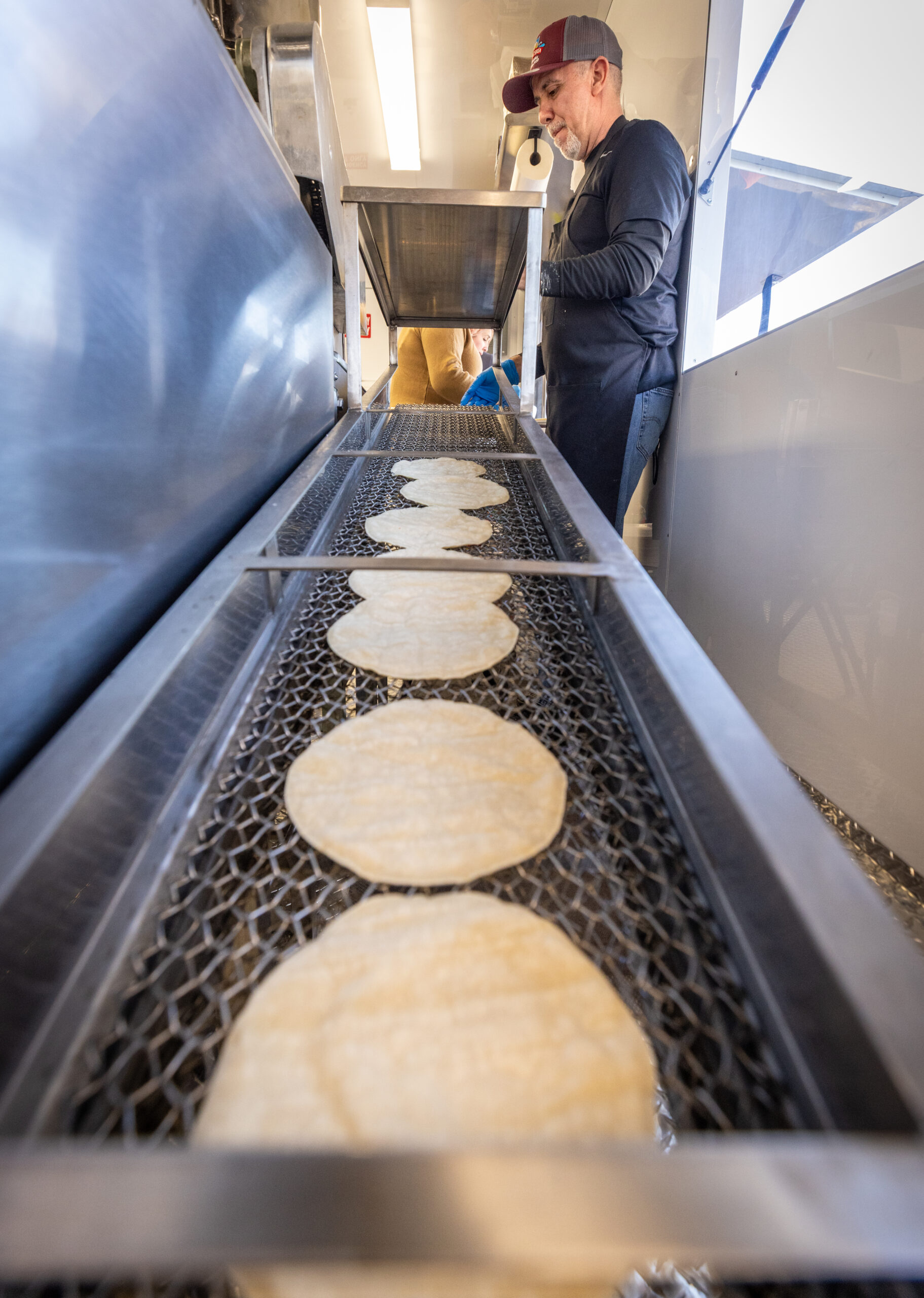 Ramiro Garcia stacks fresh corn tortillas inside the Tortilleria La Loteria 
