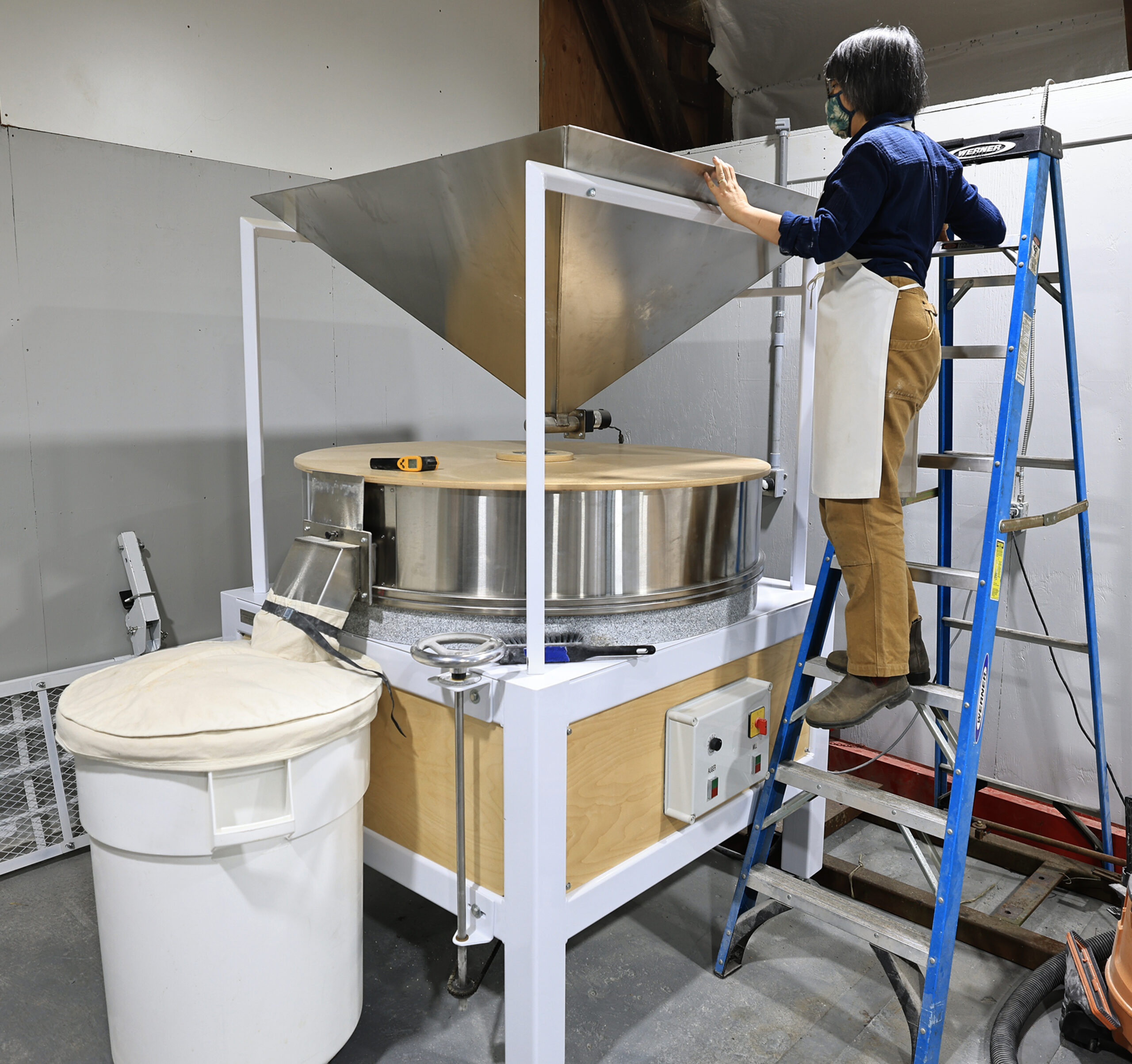 Sebastopol grain farmer Mai Nguyen begins the process of milling wheat into hard white wheat flour