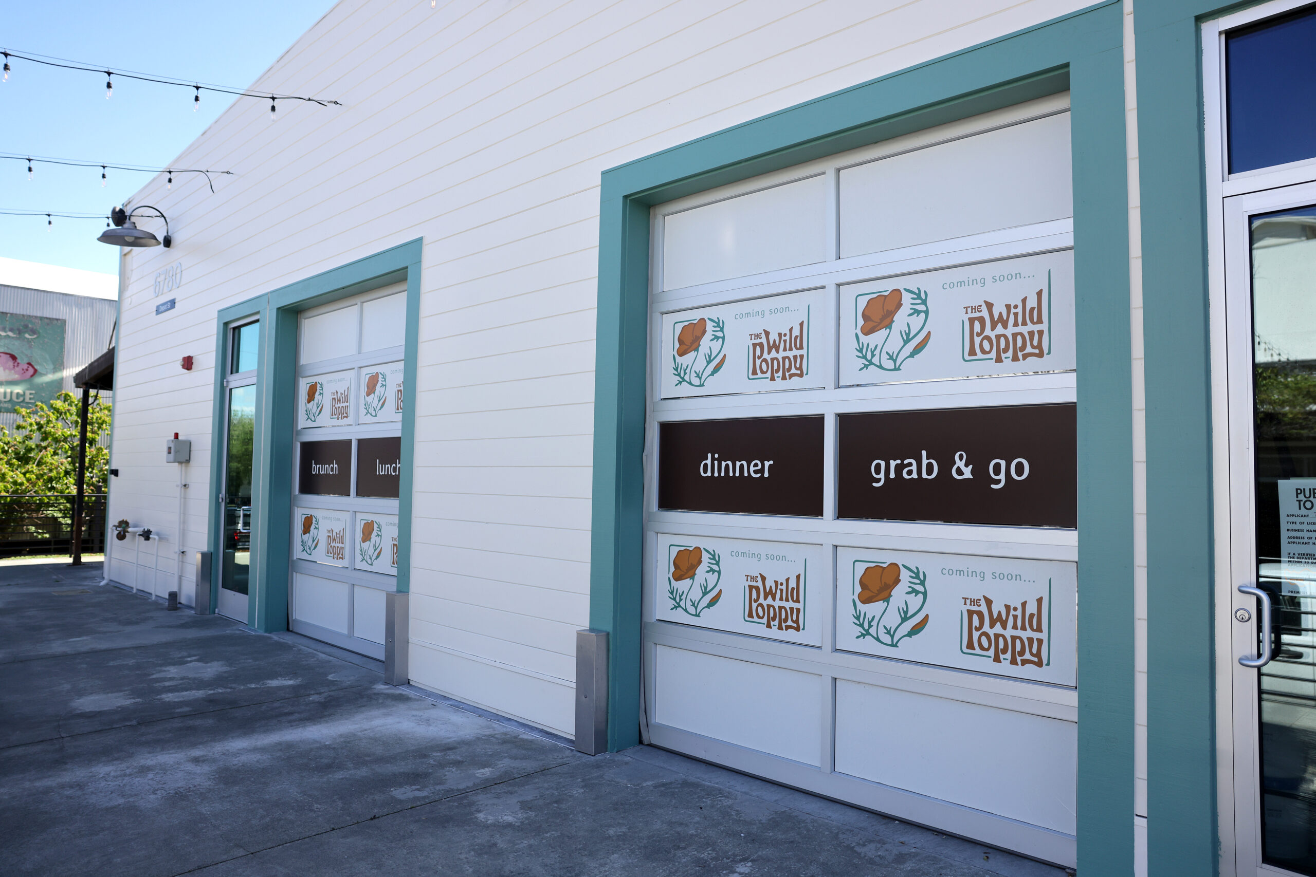 Signs for The Wild Poppy restaurant hang outside the space currently under construction at The Barlow in Sebastopol Thursday, April 2, 2026. (Beth Schlanker / The Press Democrat)
