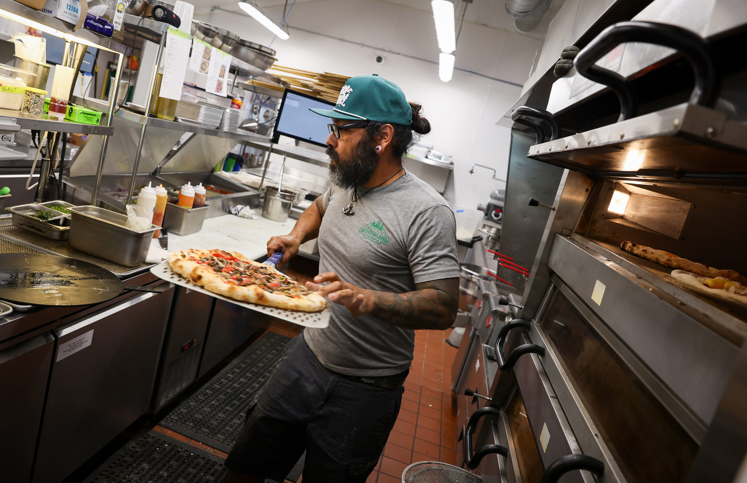 Nacho Sanchez pulls a pizza from the oven at Wonderland Pizzeria in Monte Rio