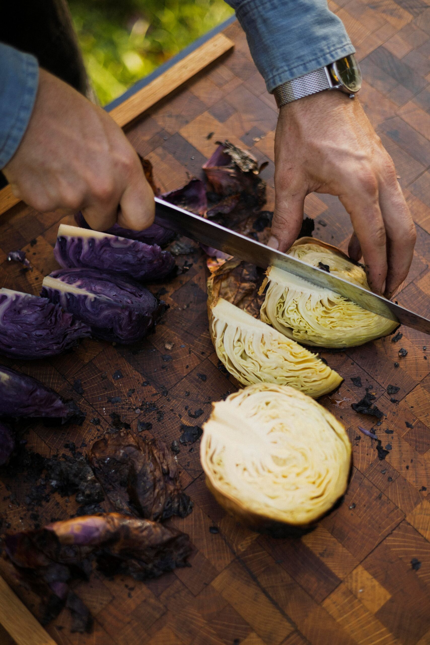 Chef Lee Desrosiers slices cabbage he slow-roasted over hot embers. (Conor Hagen)