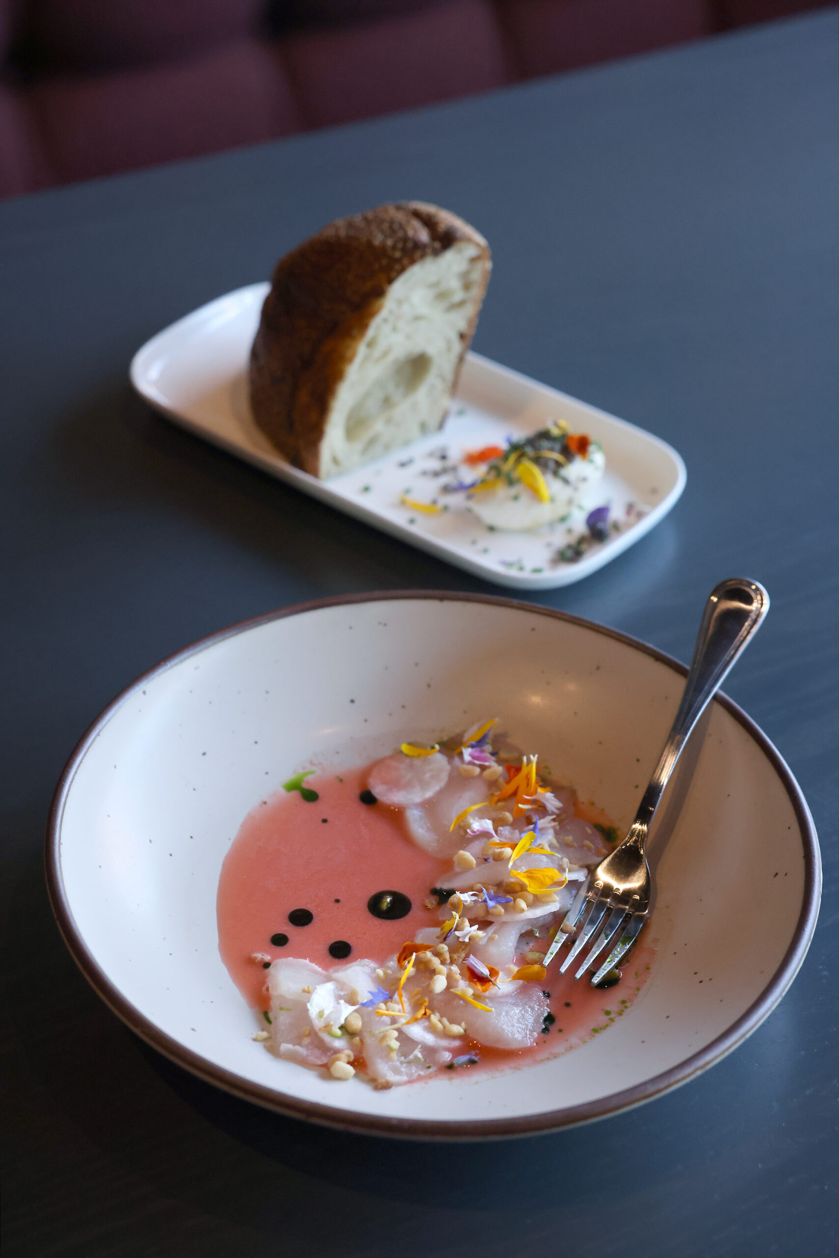 The sliced raw rockfish with strawberry aguachile, radish and pine nuts accompanied by the bread and butter, rear, at Dead Letter restaurant in Sonoma