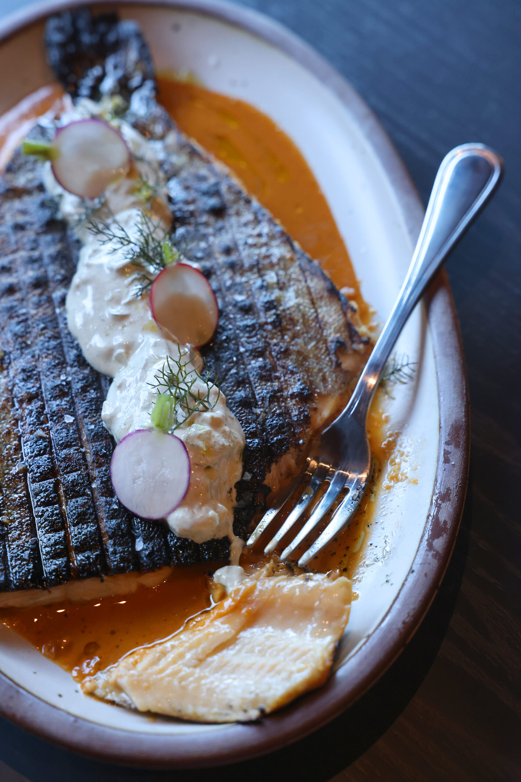Butterflied trout in a ginger red curry and topped with a cucumber yogurt sauce at Dead Letter restaurant in Sonoma