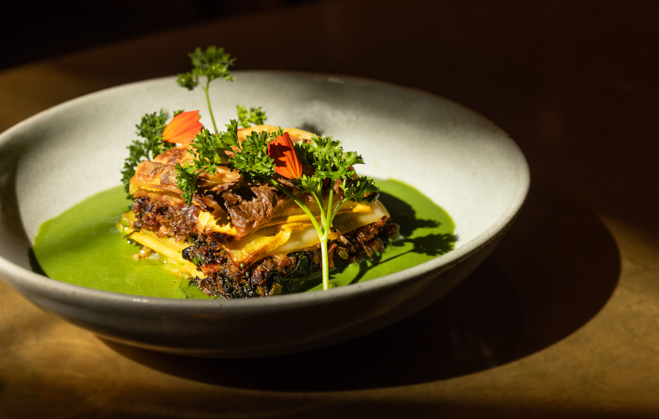 Spinach & Fennel Sausage Lasagna with Caramelized Leeks and bay-Infused Béchamel, cultured cashew mozzarella and spinach salsa from Little Saint in Healdsburg. (John Burgess/The Press Democrat)