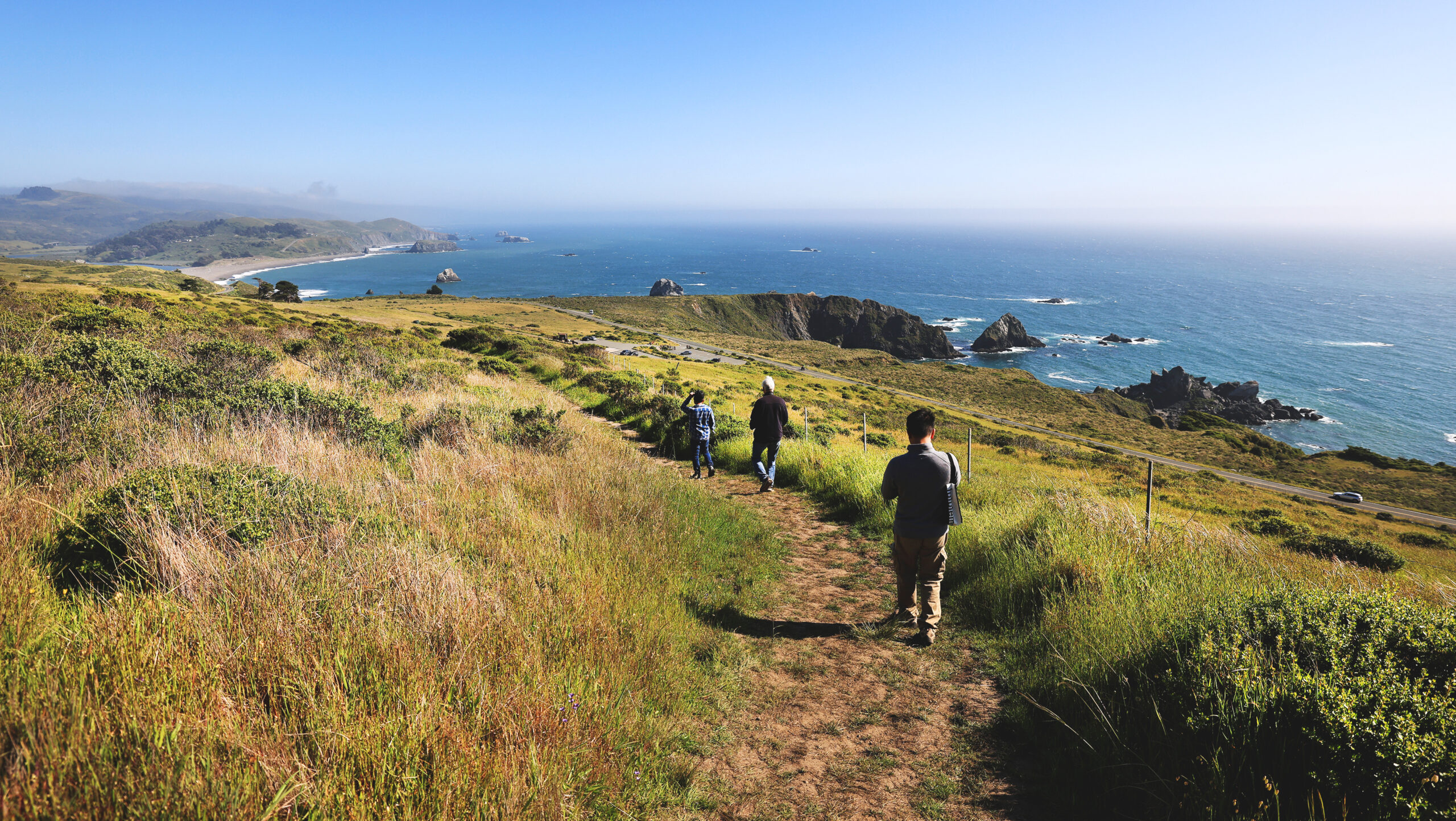 Lin Khuu, Tim Cahn and Minh Ta descend from Sentinel Point on the Sea to Sky Trail at Jenner Headlands Preserve, Thursday, April 30, 2026. (Kent Porter / The Press Democrat)