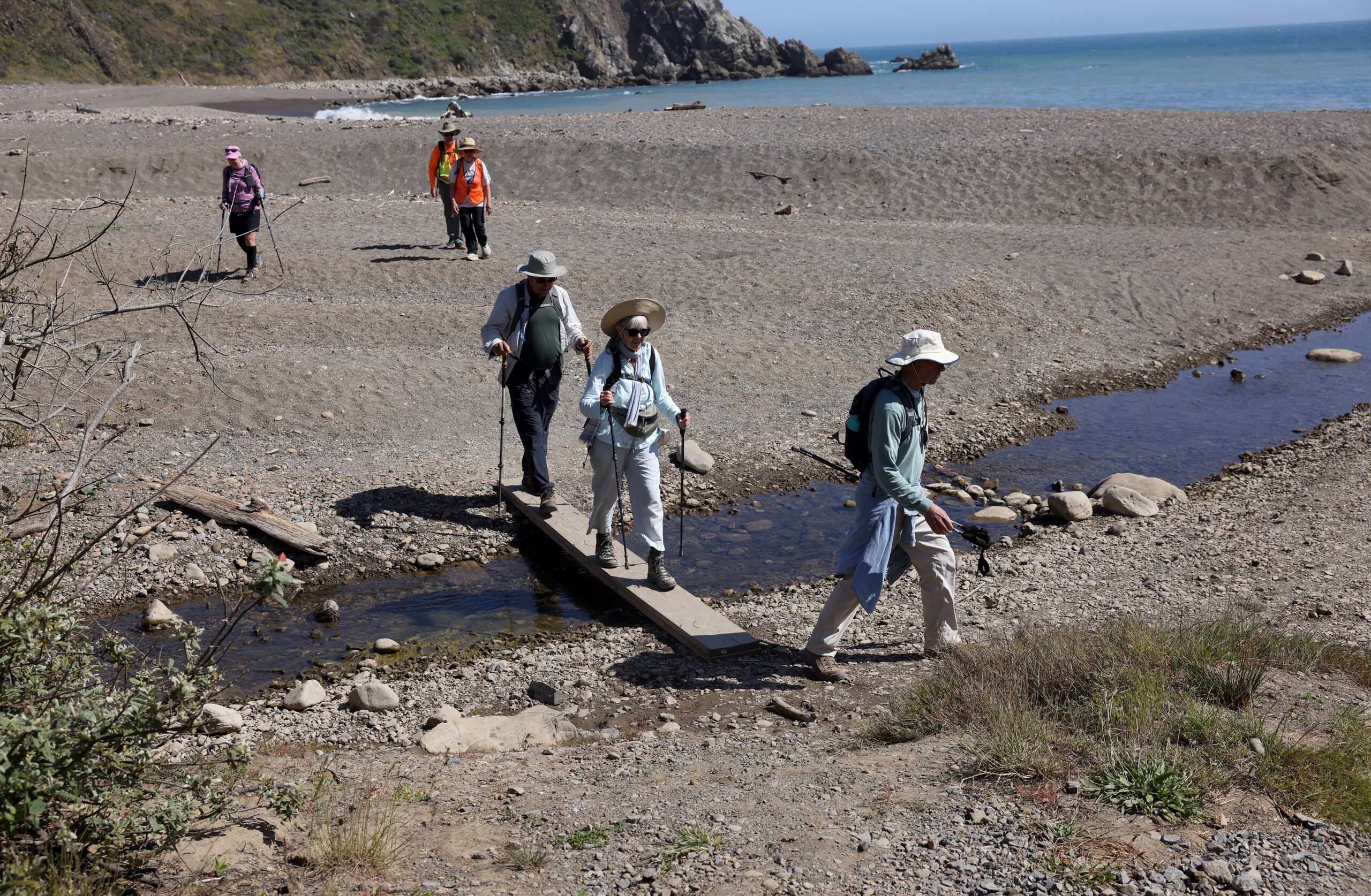 Hikers cross a footbridge at Sandy Cove during the Camino de Sonoma in Fort Ross on Tuesday, May 19, 2026. (Beth Schlanker / The Press Democrat)