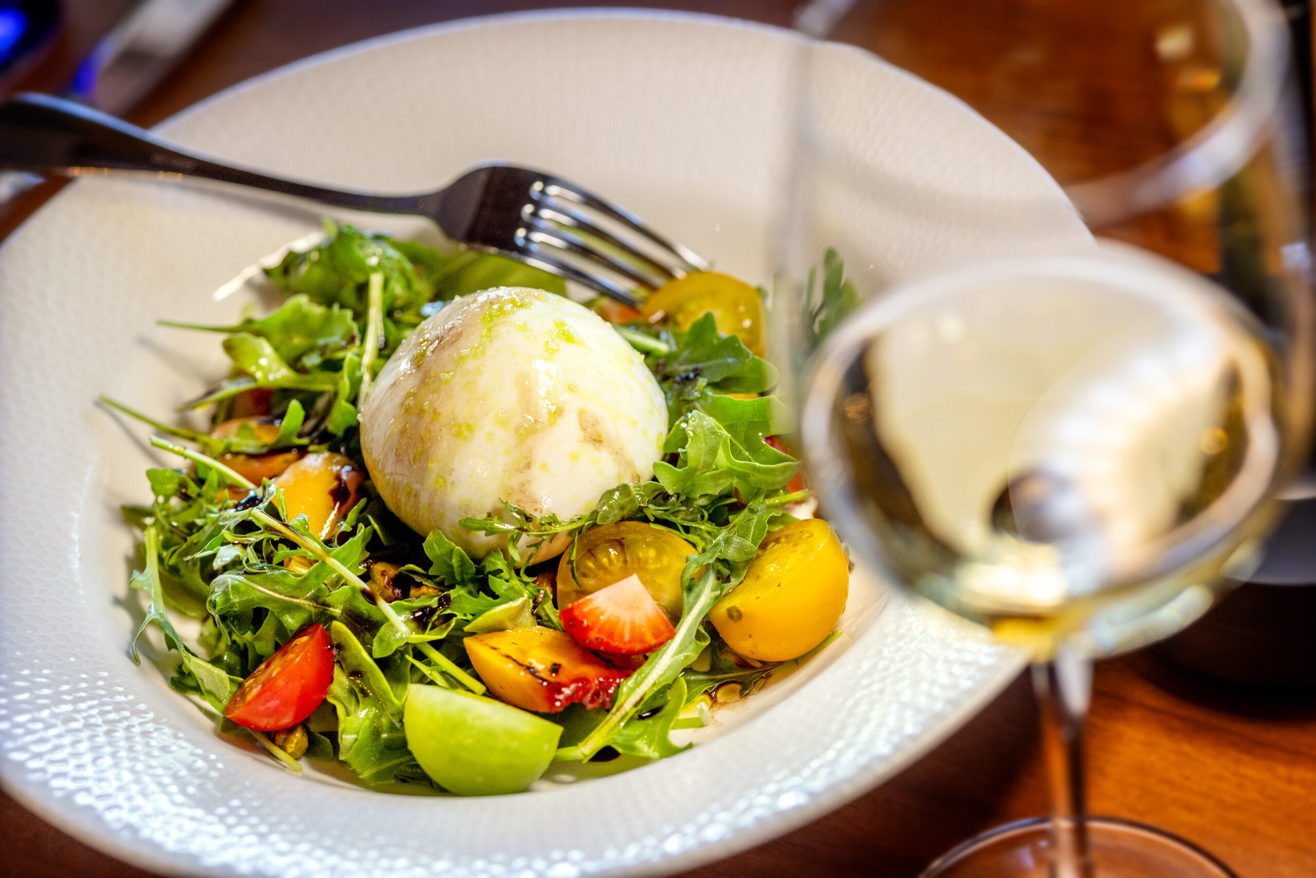 Burrata Salad with baby arugula, grilled seasonal fruit, heirloom tomato, basil, pistachio, aged balsamic from Capriciano Osteria Thursday, July 30, 2026 in Santa Rosa. (John Burgess/The Press Democrat)