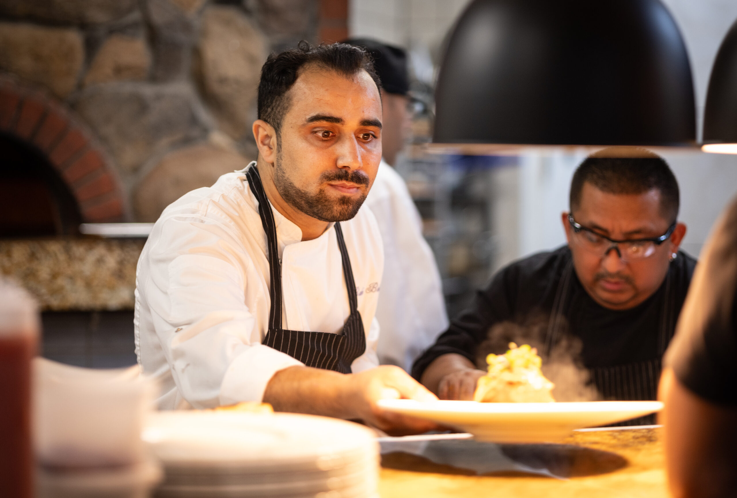Owner/chef Baki Bekci finishes plates in the kitchen at Capriciano Osteria