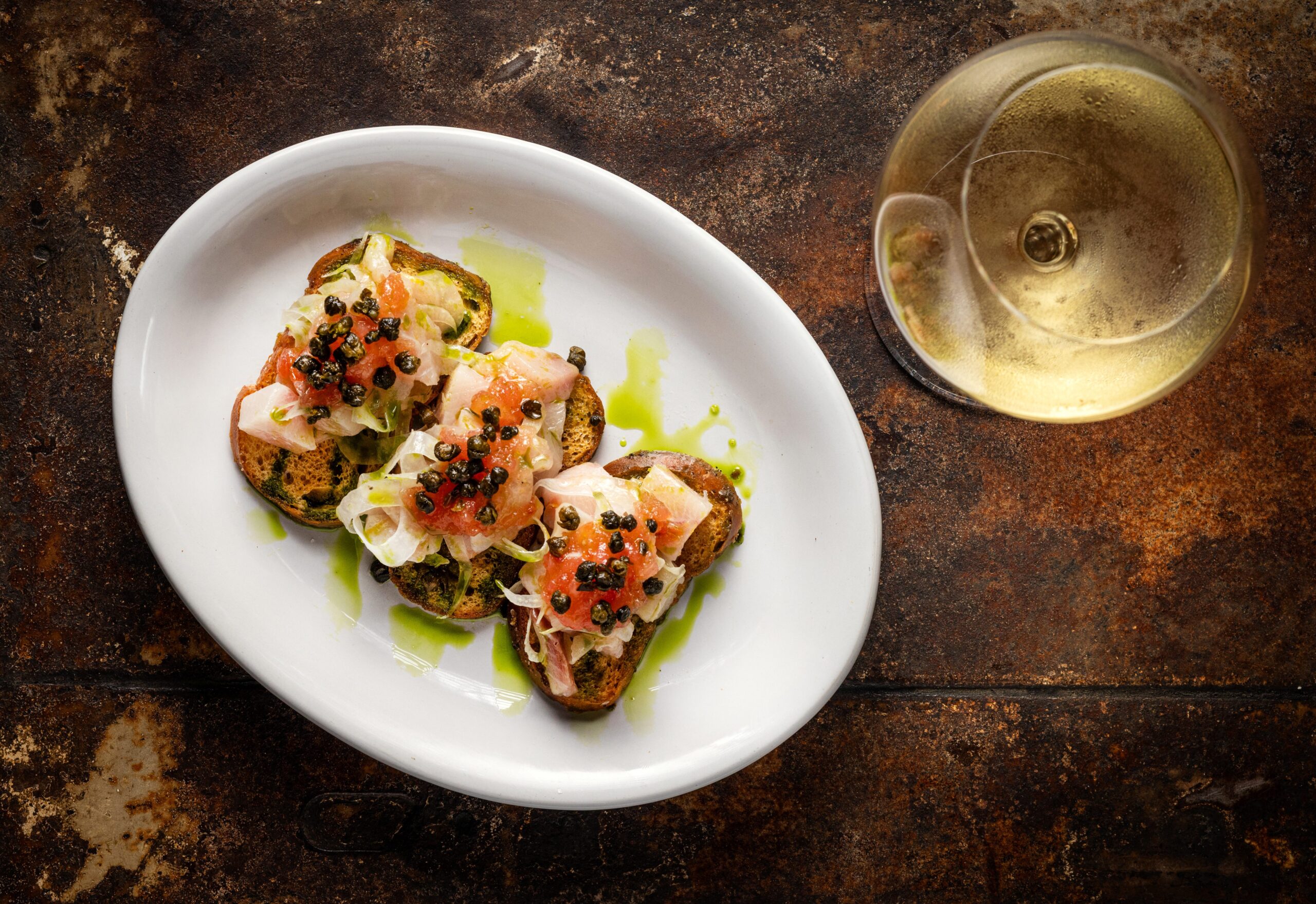 The daily Crudo Special with Hamachi, shaved fennel, with fresh tomato and capers from Lo & Behold Monday, Aug. 3, 2026 in Healdsburg. (John Burgess/The Press Democrat)