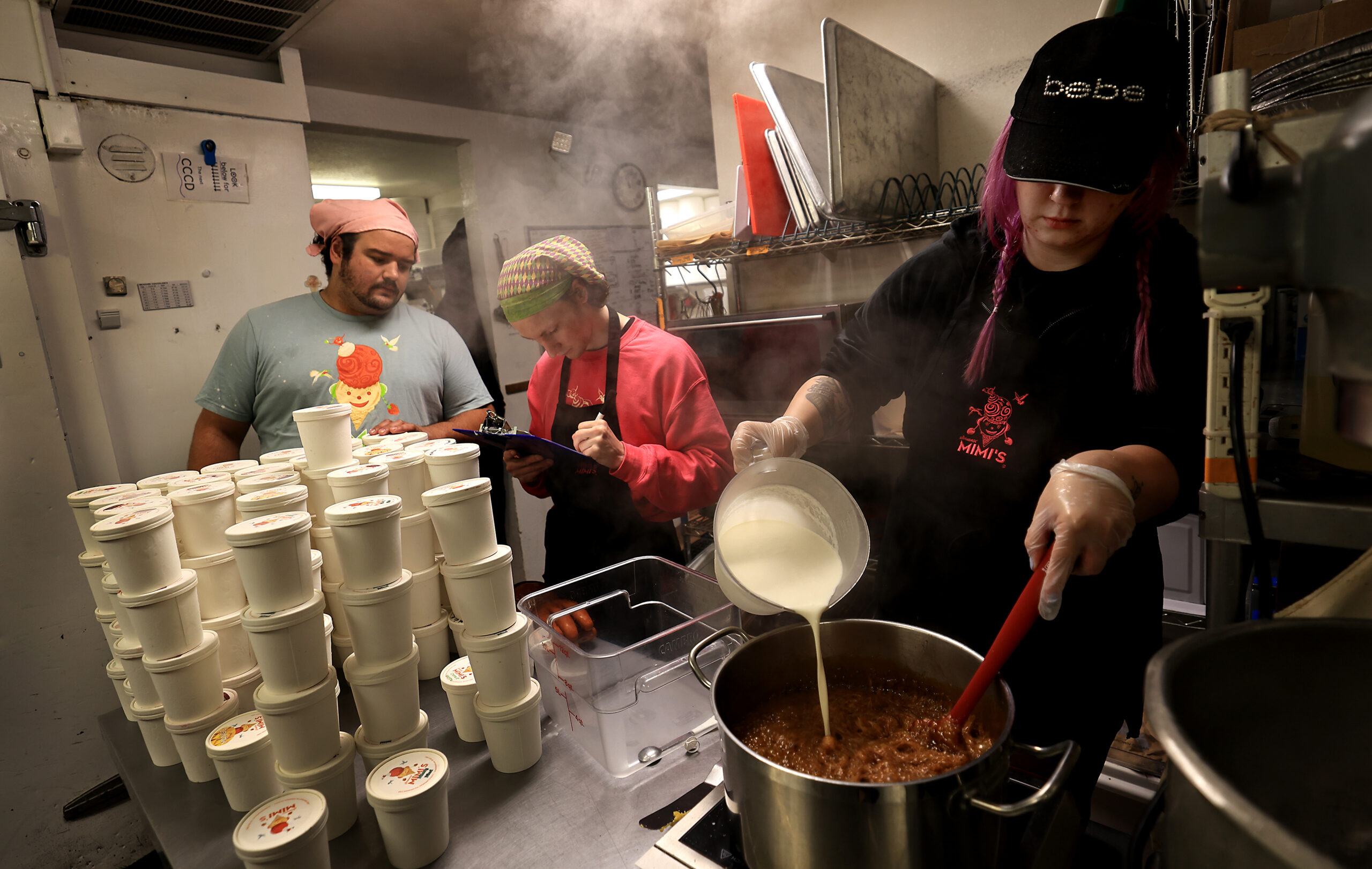 From left, Carter Olson and Oskar Grophe inventory pints of ice cream as Lynsey Rasmussen creates a new flavor, Wednesday August 12, 2026, at Screamin' Mimi's in Sebastopol. (Kent Porter / The Press Democrat)